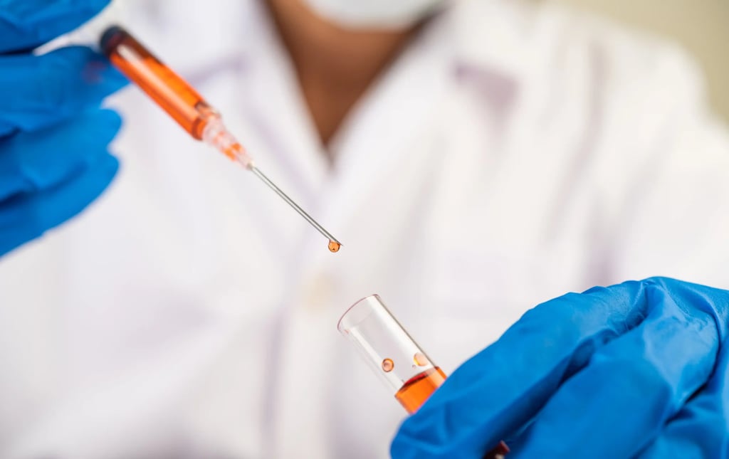 Stem Cell Therapy in Tijuana, Mexico 12 Close-up of a syringe with a drop of orange liquid being prepared for regenerative medicine Mexico in a professional laboratory.