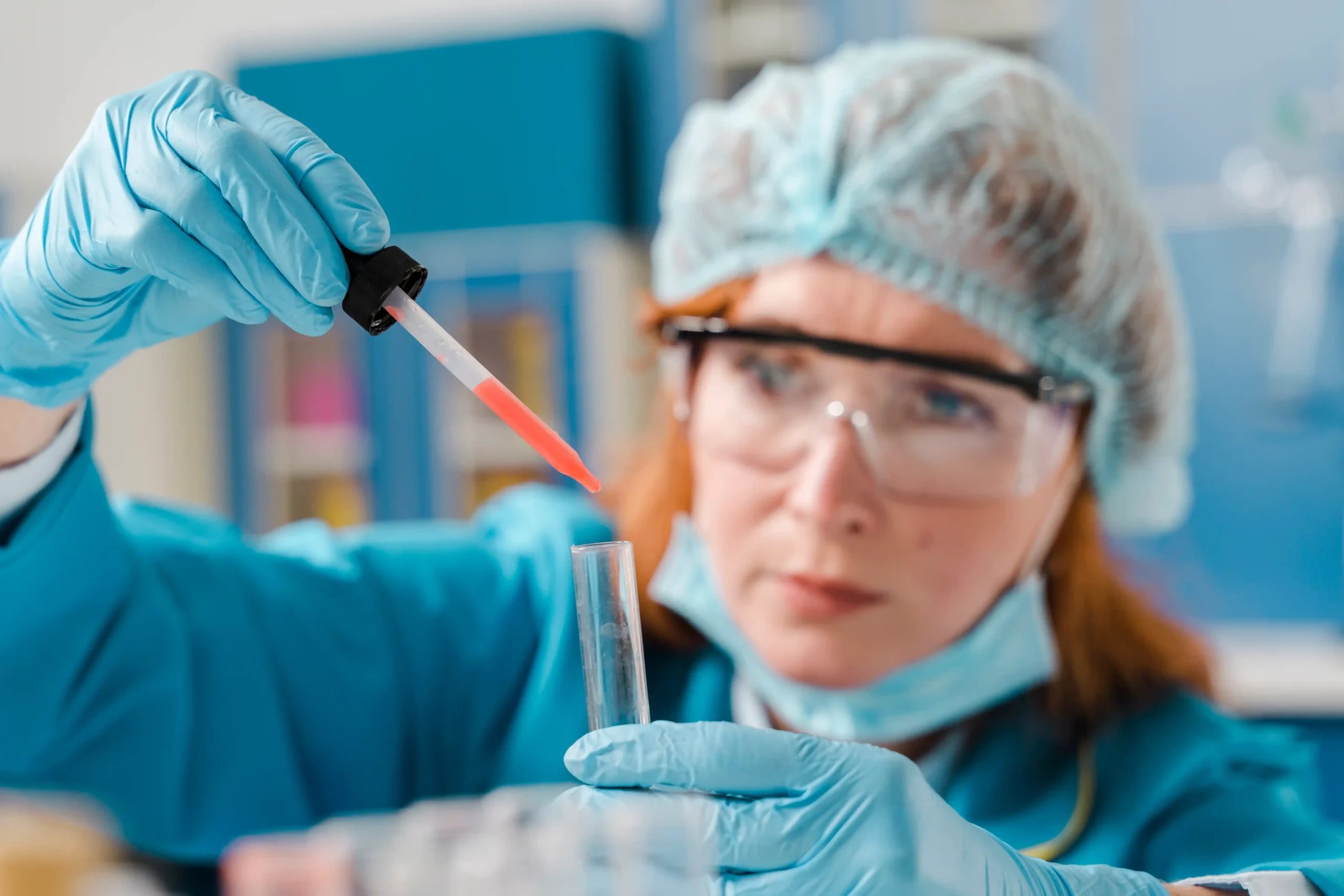 Stem Cell Therapy in Tijuana, Mexico 18 Female scientist in blue protective gear using a pipette for sample testing in a stem cell therapy lab in Tijuana.