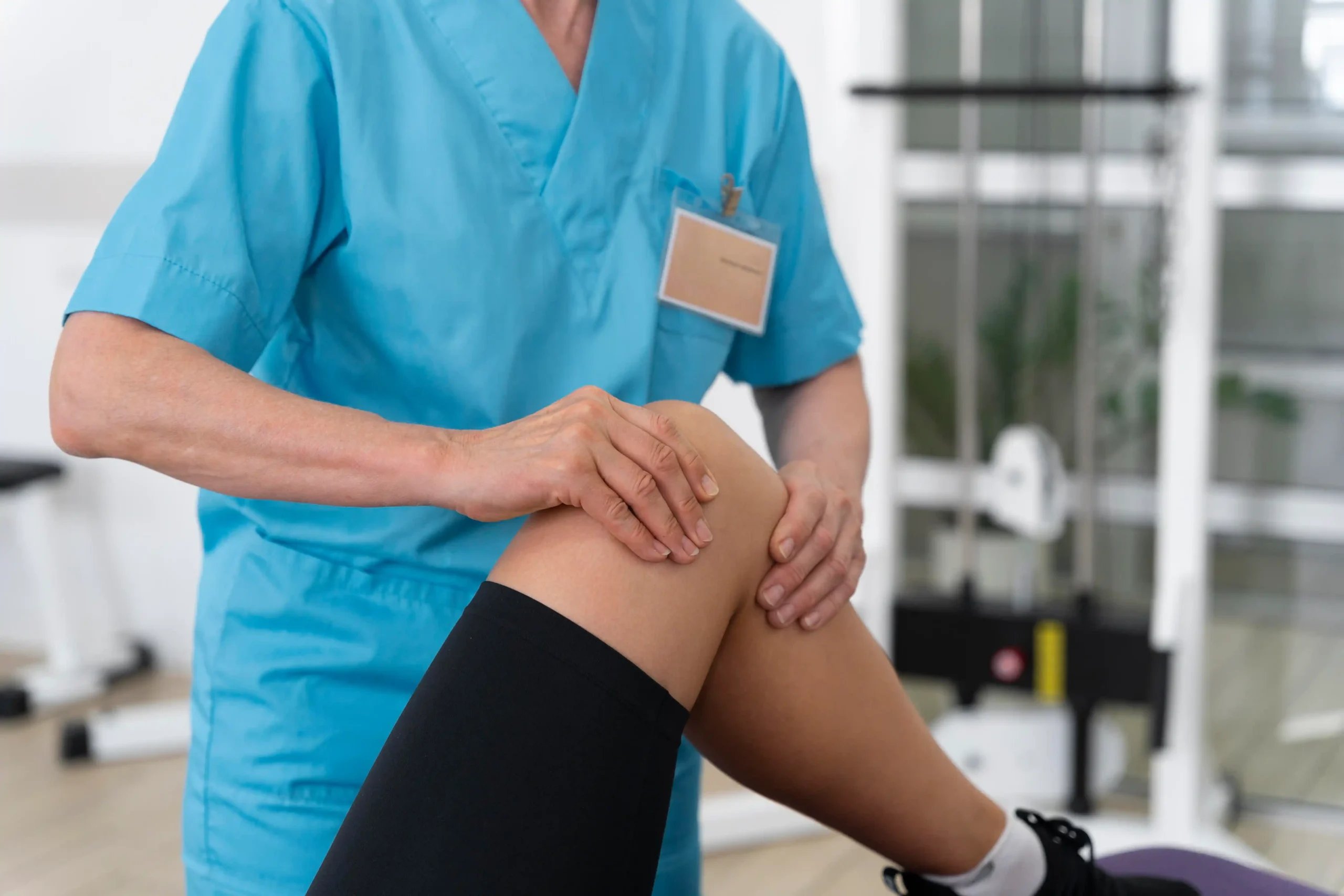 Knee Arthroscopy in Tijuana, Mexico 11 Medical assistant helping a patient with physiotherapy exercises after knee arthroscopy in Tijuana.