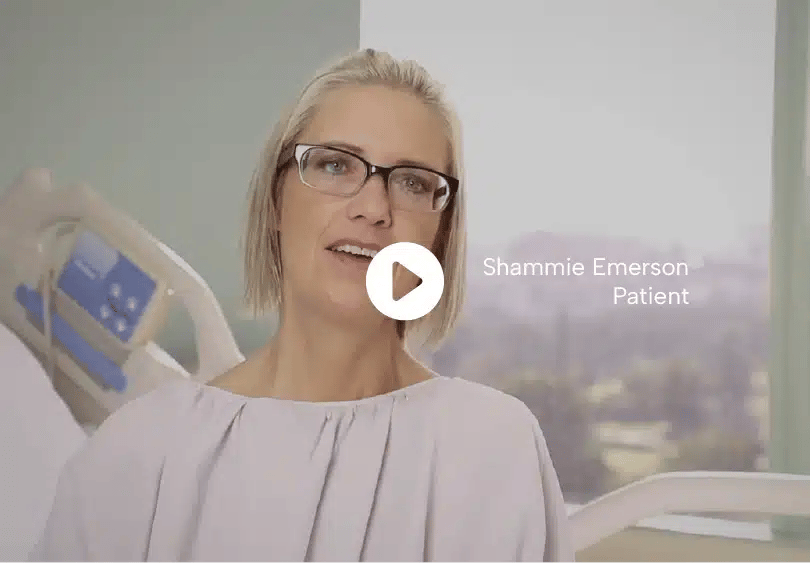 Medical Tourism in Tijuana | Affordable Surgery Packages 14 Shammie Emerson, patient, sitting on a hospital bed, smiling confidently while speaking to the camera.