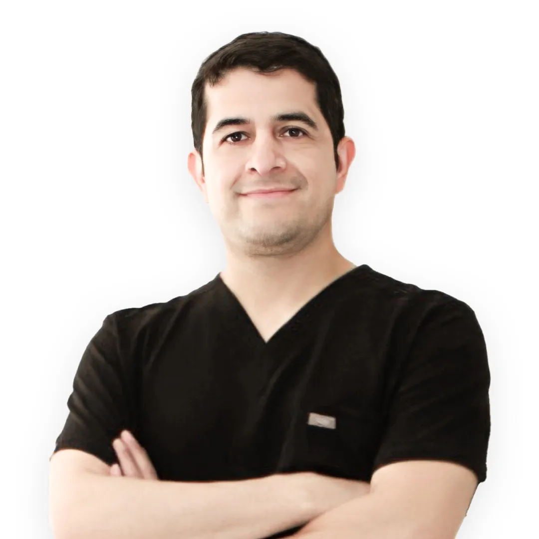 Mommy Makeover in Tijuana, Mexico — Restore Your Confidence 17 Professional portrait of Dr. Ismael Gonzalez, a surgeon, with his arms crossed and wearing black surgical scrubs.