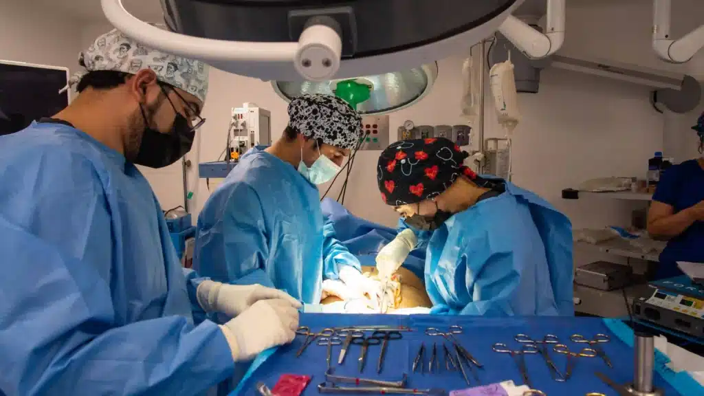 Transgender Surgery in Tijuana, Mexico 12 Surgical team in Tijuana performing a gender affirmation surgery in a sterile operating room, focusing on surgical instruments for precision and patient safety.