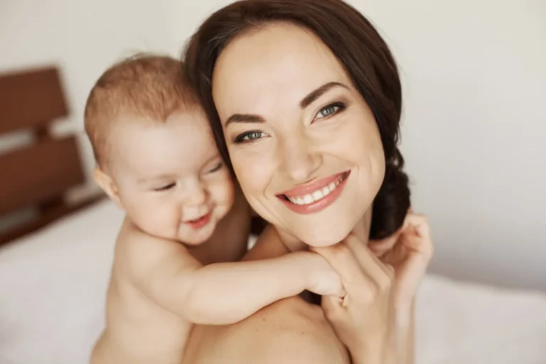 Radiant mother with baby, illustrating the celebrity post pregnancy body look achieved through a celebrity mommy makeover and tummy tuck after pregnancy.