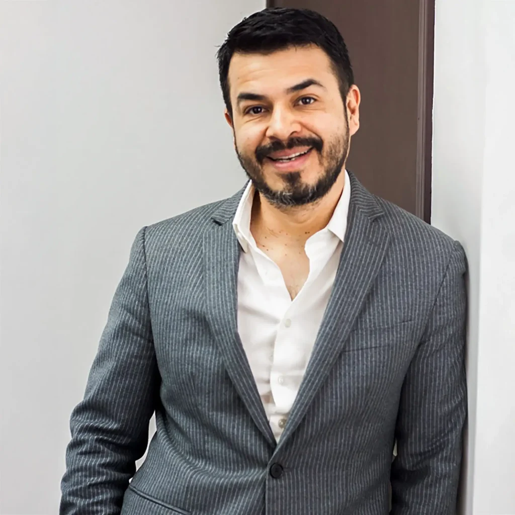 Rhinoplasty in Tijuana, Mexico 15 Portrait of Dr. Marco Rodas, a highly experienced board-certified plastic surgeon in Tijuana, smiling in a grey suit, representing the medical excellence of HWBazaar.