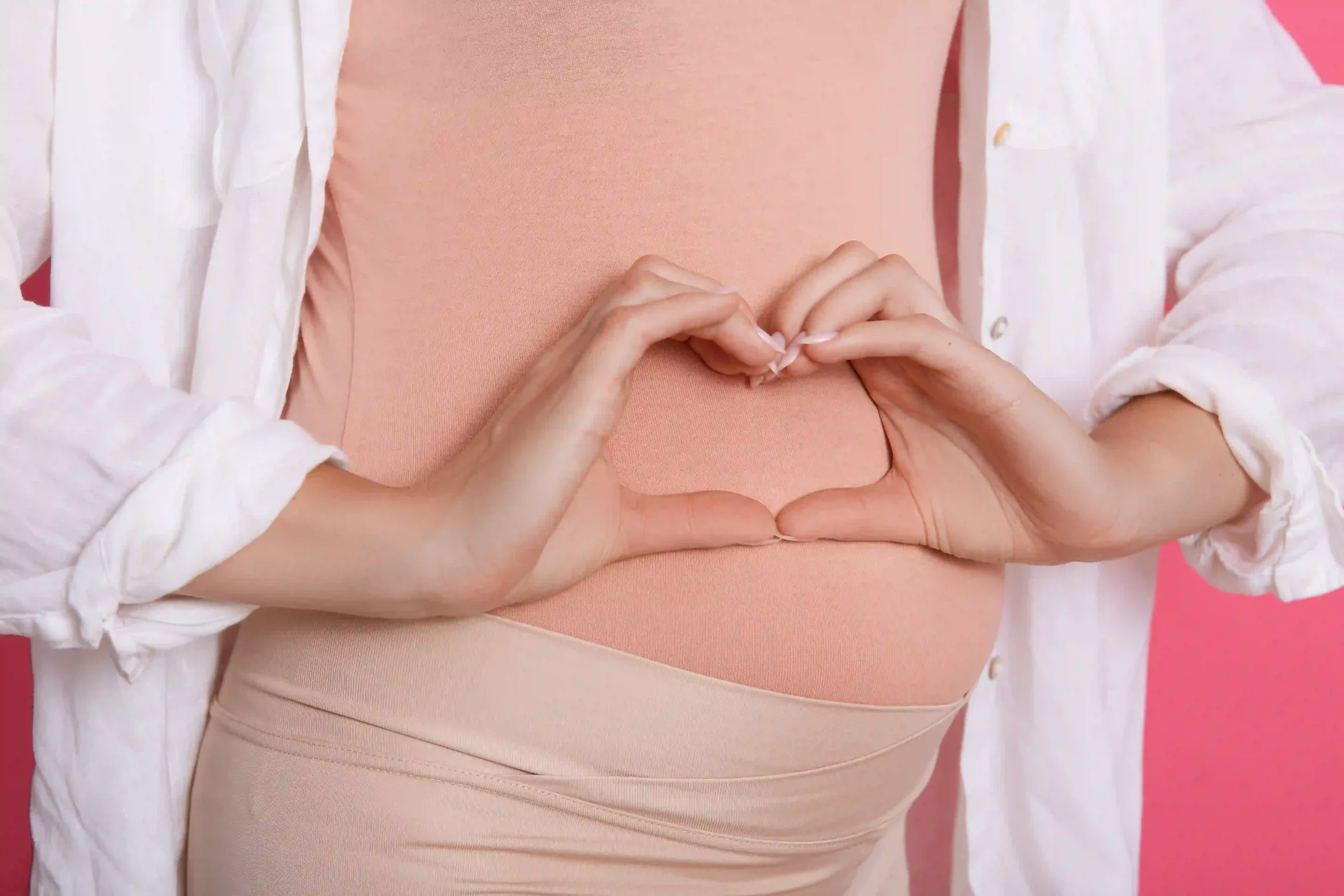 Gastric Balloon in Tijuana, Mexico 11 A healthy pregnant woman making a heart shape over her belly, showing the long-term fertility benefits of a gastric balloon in Tijuana.