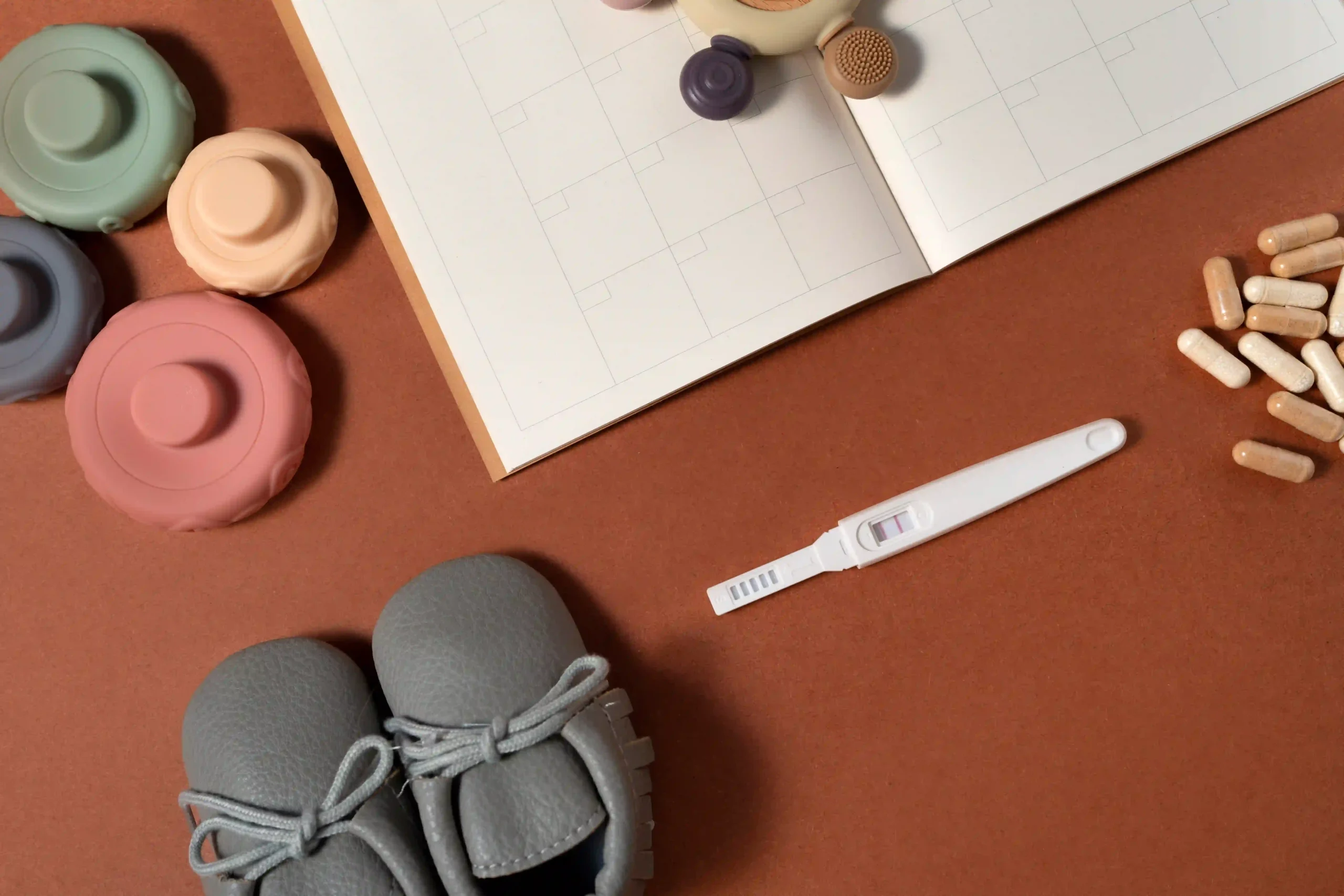 Fertility Clinics in Tijuana, Mexico 18 A positive pregnancy test next to vitamins and baby shoes, representing the journey and cost of IVF in Tijuana and successful fertility treatments in Tijuana.