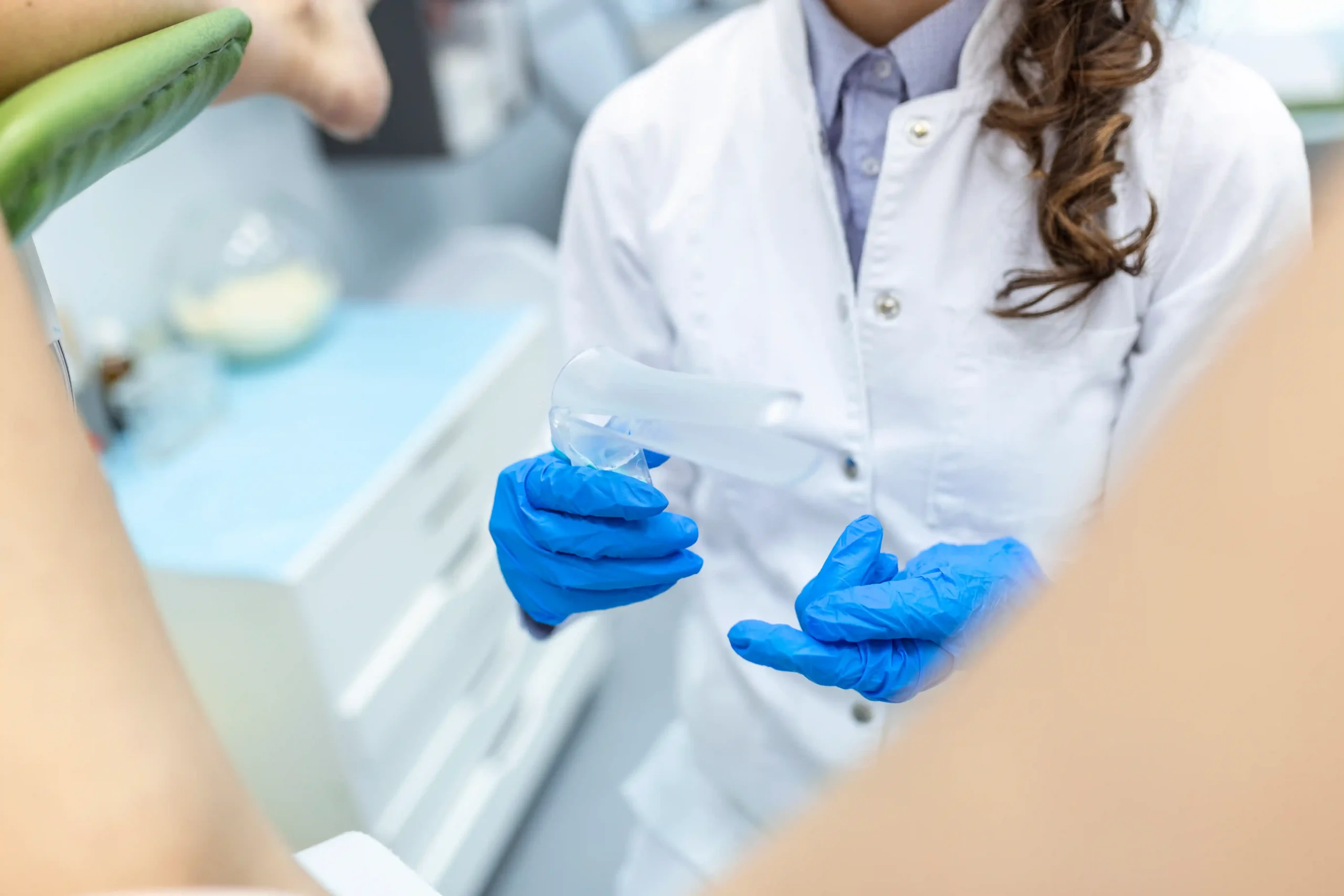 Fertility Clinics in Tijuana, Mexico 14 A female gynecologist in a white coat and blue gloves during a consultation, ensuring safe fertility treatments abroad and professional fertility preservation Tijuana.
