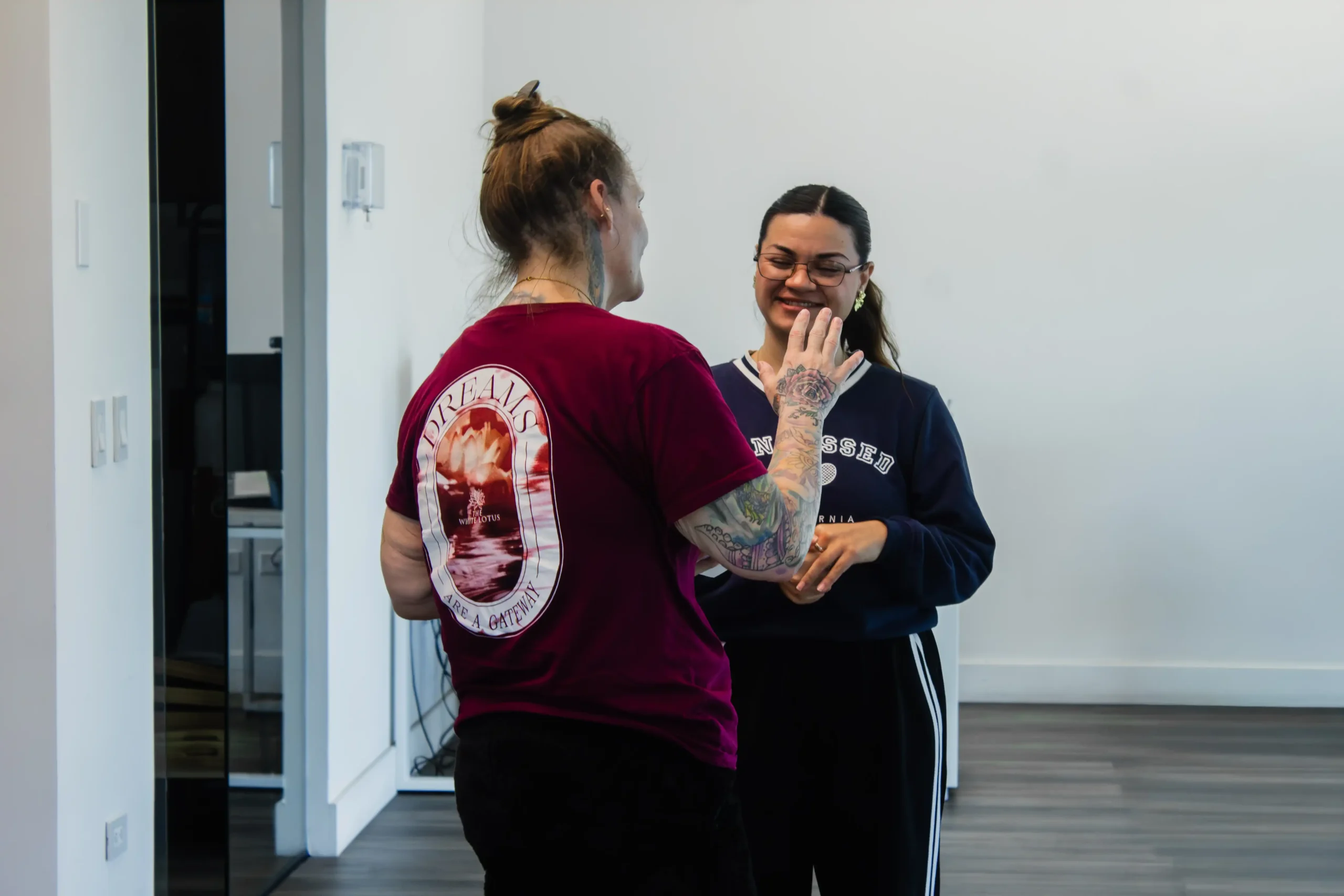 Spinal Disc Regeneration in Tijuana, Mexico 13 Two women in a friendly conversation at a modern medical clinic providing stem cell therapy for disc regeneration in Tijuana.