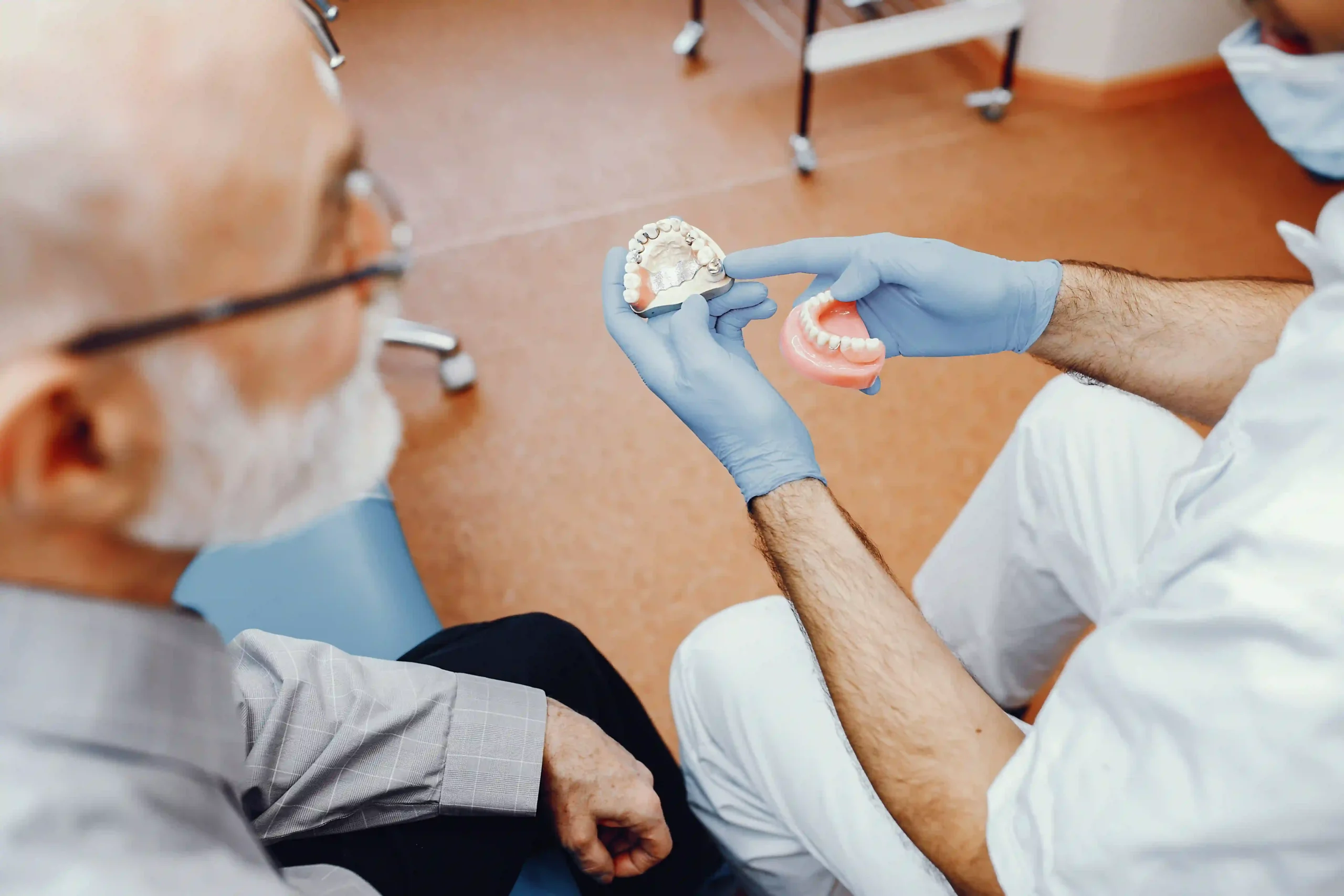Dentures in Tijuana, Mexico 12 A senior patient consulting with a dentist about partial dentures in Tijuana using a dental model.