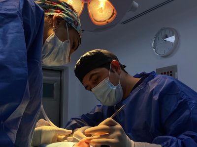 A surgeon performing rhinoplasty (nose surgery) in a modern operating room in Tijuana, Mexico. The advanced surgical lighting highlights the state-of-the-art medical facilities and experienced surgeons at Health & Wellness Bazaar, a leading provider of affordable cosmetic surgery in Mexico.